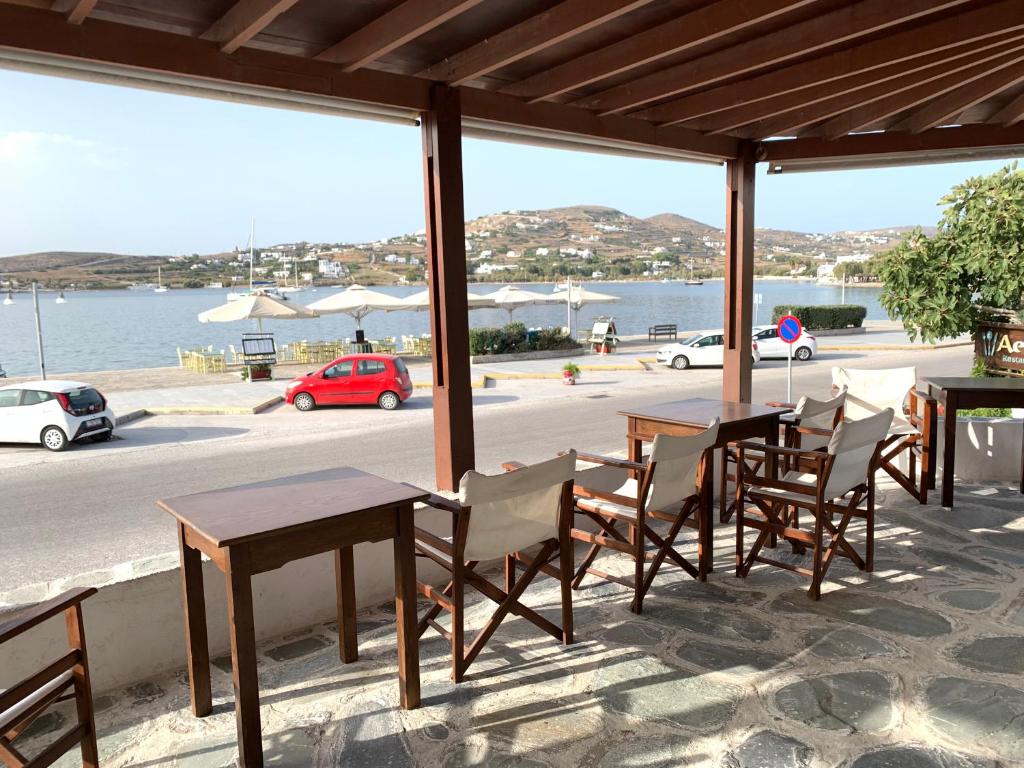 un patio con tavoli, sedie e un secchio d'acqua di Asterias Hotel - Seafront a Paroikia