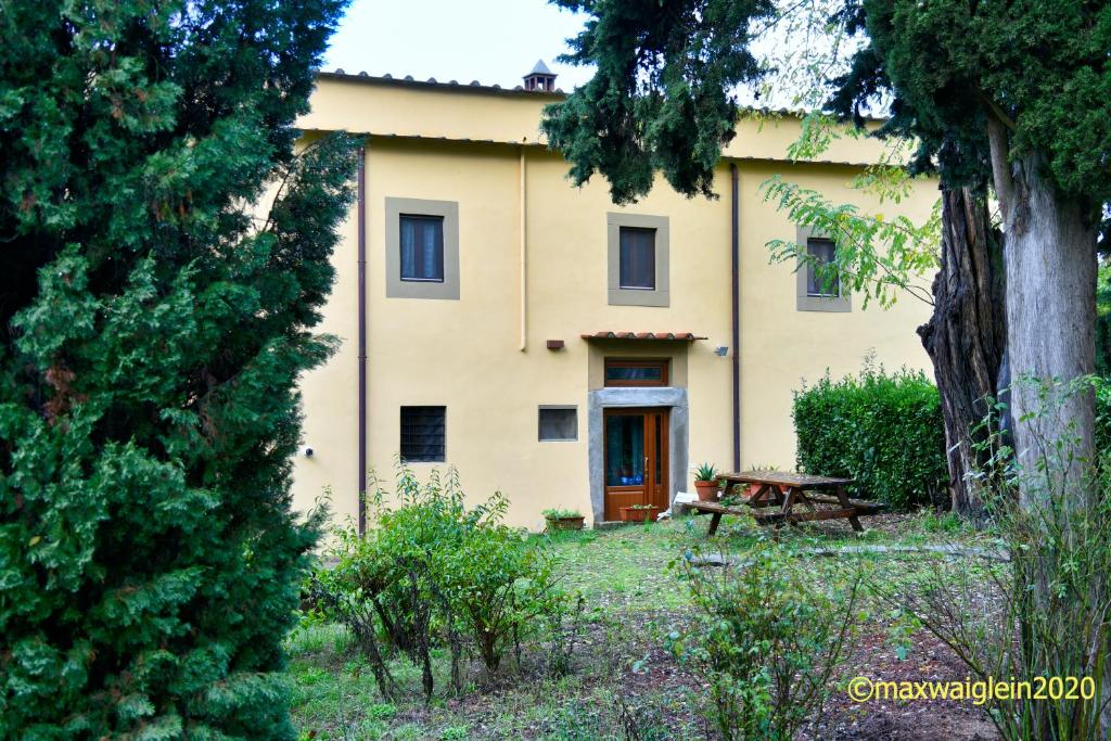 a large yellow house with a picnic table in front of it at Buonincontro Apartment in Florence