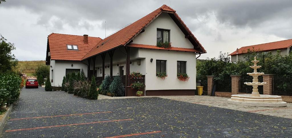 une maison blanche avec un toit rouge et une allée. dans l'établissement Casa Cu Pridvor, à Băile Felix