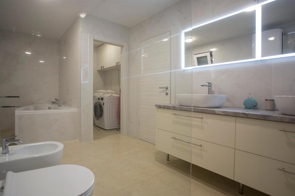 a white bathroom with two sinks and a toilet at Luxury Blue Villas Vis in Vis