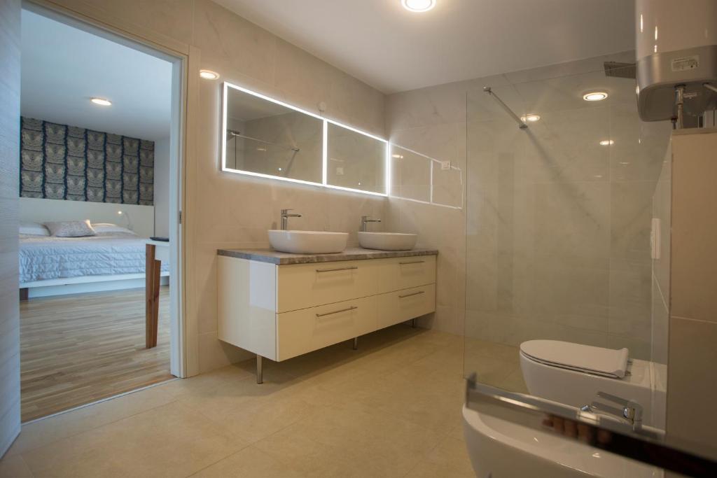 a bathroom with two sinks and a toilet and a bed at Luxury Blue Villas Vis in Vis
