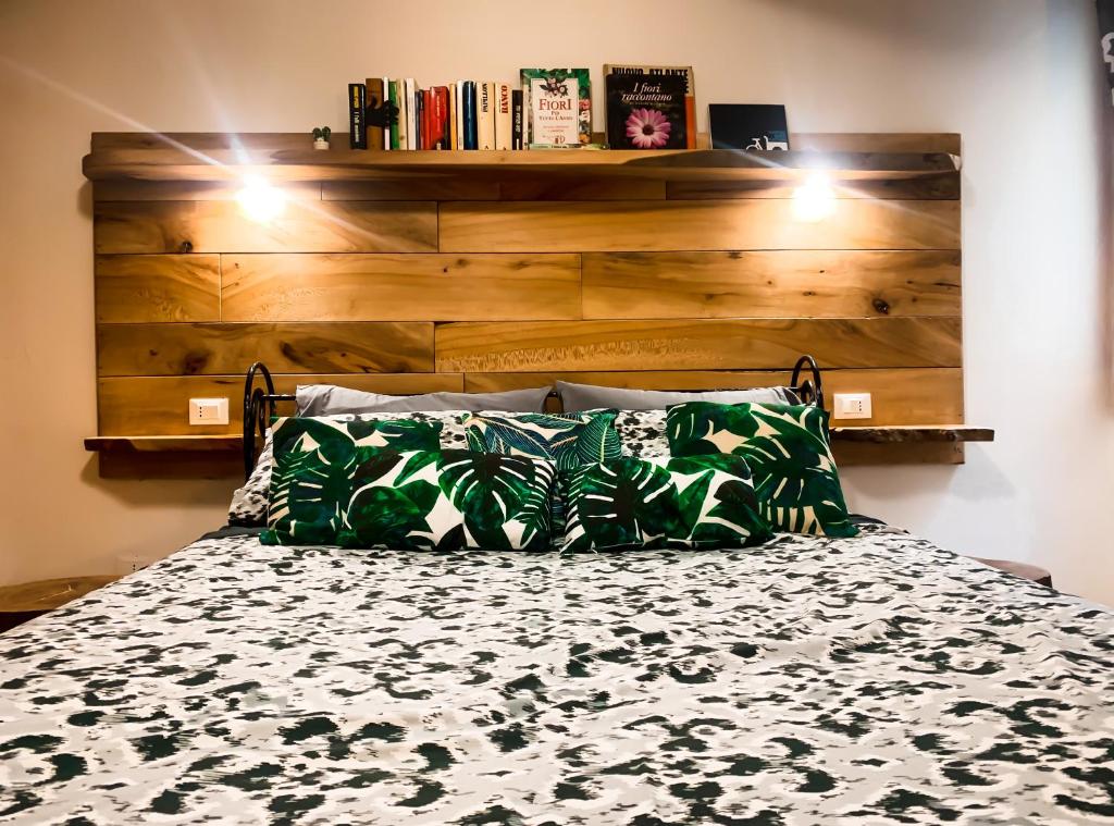 1 dormitorio con 1 cama con cabecero de madera en Grazioso bilocale pieno centro, en Módena