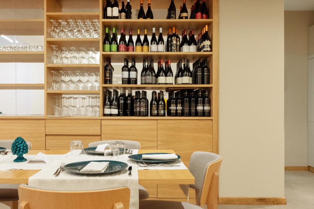 a dining room with a table and a shelf of wine bottles at Albatros Beach Hotel in Letojanni