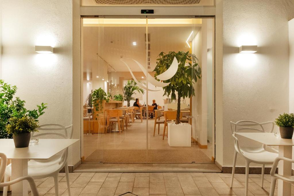 a dining room with tables and chairs and a glass door at Albatros Beach Hotel in Letojanni