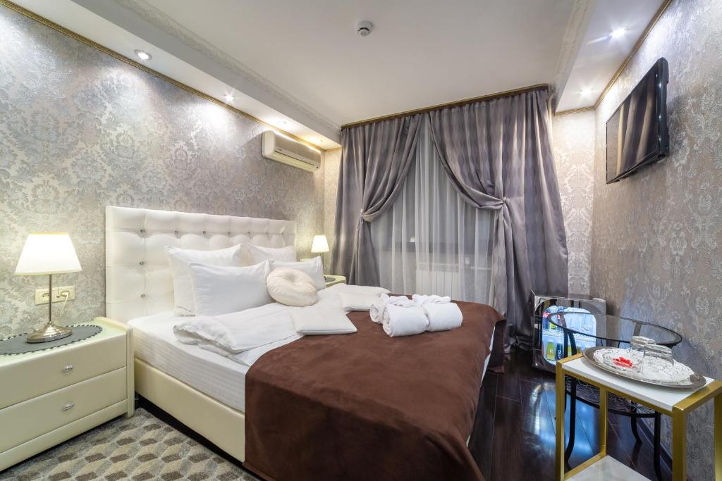 a bedroom with a large bed with towels on it at Отель Бомонд на Ленинском Проспекте in Moscow