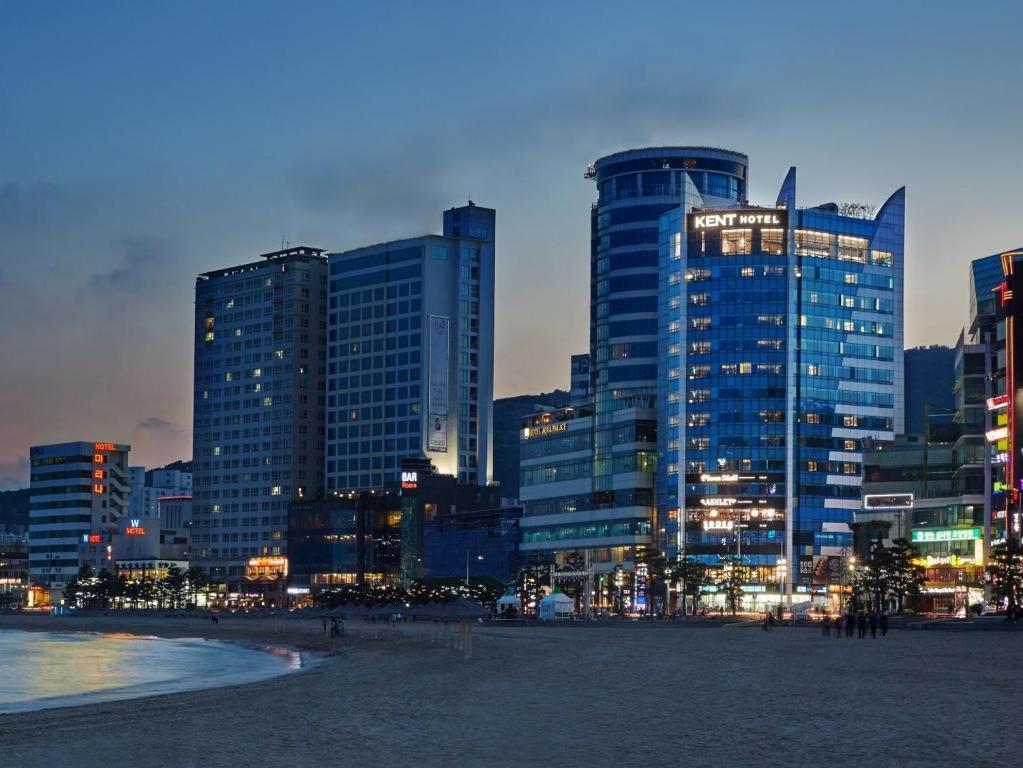 um horizonte da cidade à noite com edifícios altos em Kent Hotel Gwangalli by Kensington em Busan