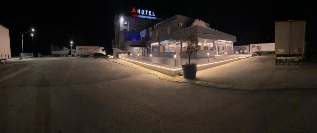 un estacionamiento por la noche con un edificio y una planta en Asselta Hotel, en Cerignola