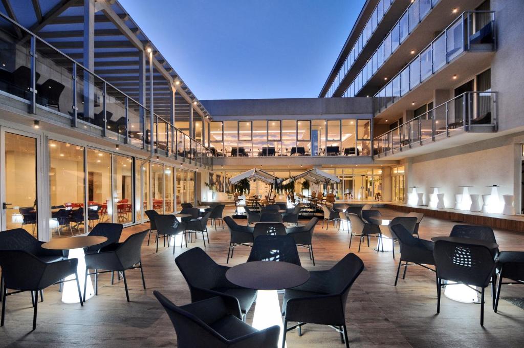 a restaurant with tables and chairs in a building at Marina Palace Hotel 4 stelle S in Caorle