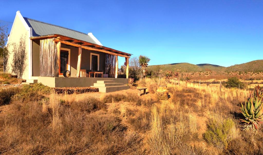 a small house in the middle of a field at River View Cottages in Calitzdorp