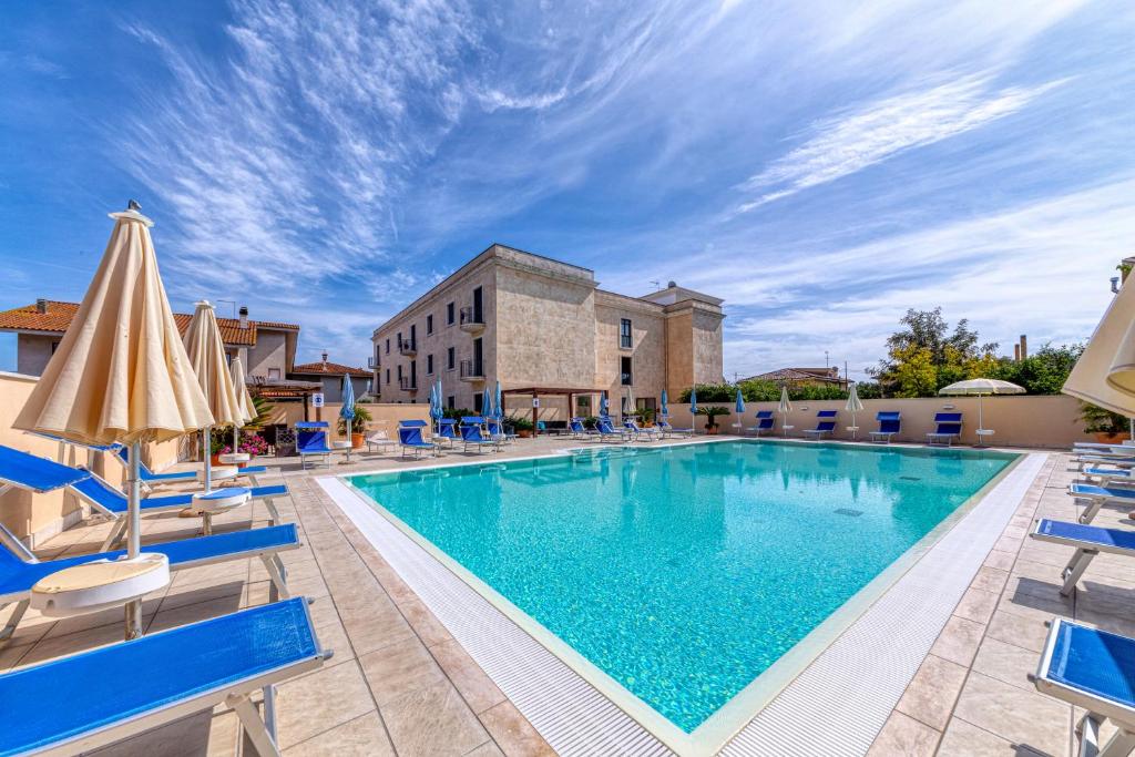 - une piscine dans un complexe avec des chaises et des parasols dans l'établissement Hotel Le Torri, à Arborea