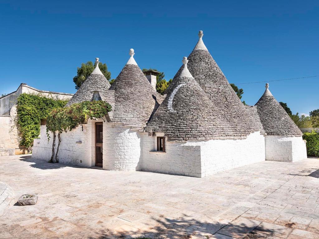an old house with a roof with ivy on it at Trulli Uliveto Acquafonda in Alberobello