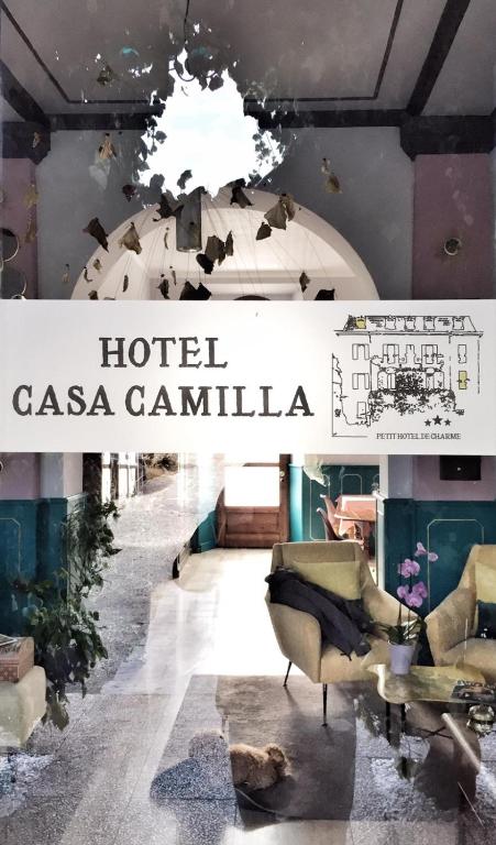 a sign for a hotel casa cantina with chairs and a table at Hotel Casa Camilla in Verbania