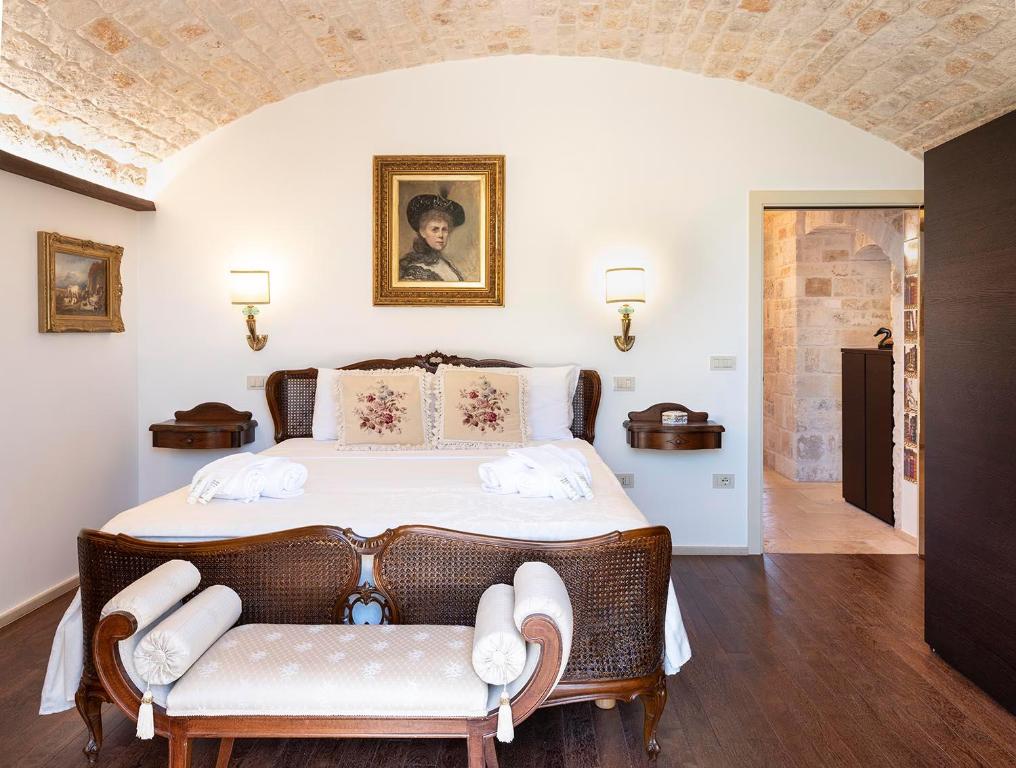 sypialnia z dużym łóżkiem z 2 krzesłami w obiekcie Trulli Uliveto Acquafonda w Alberobello