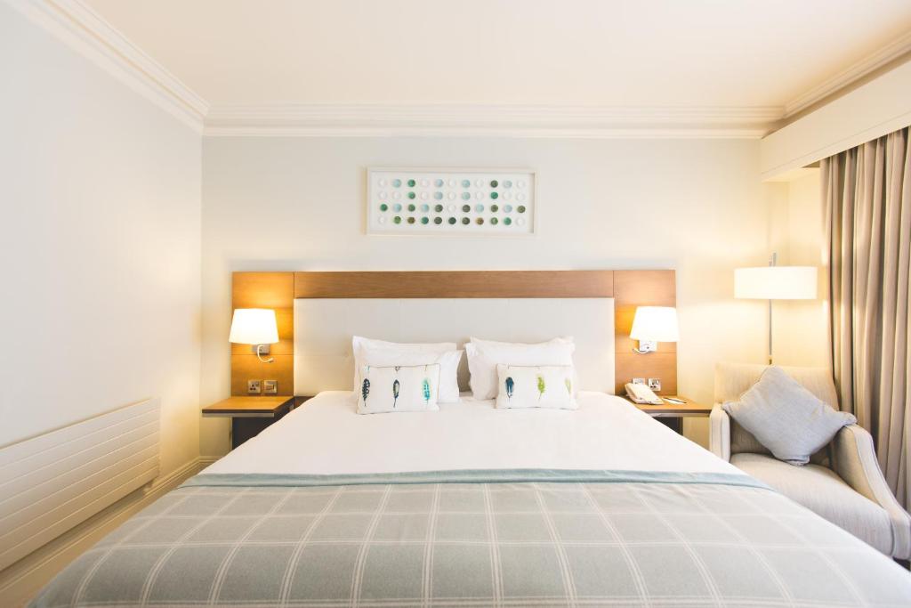 a bedroom with a large white bed with two pillows at Portmarnock Resort & Jameson Golf Links in Portmarnock