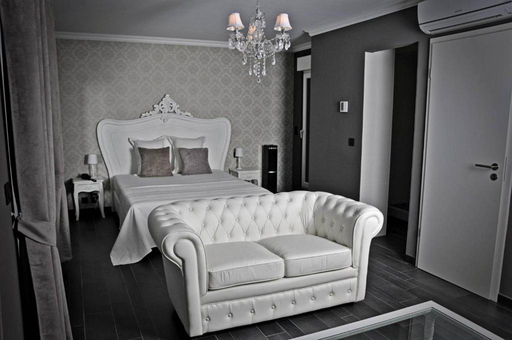 um quarto com uma cama branca e um sofá em V E R O N E - Rooms & Suites - Liège - Rocourt em Liège