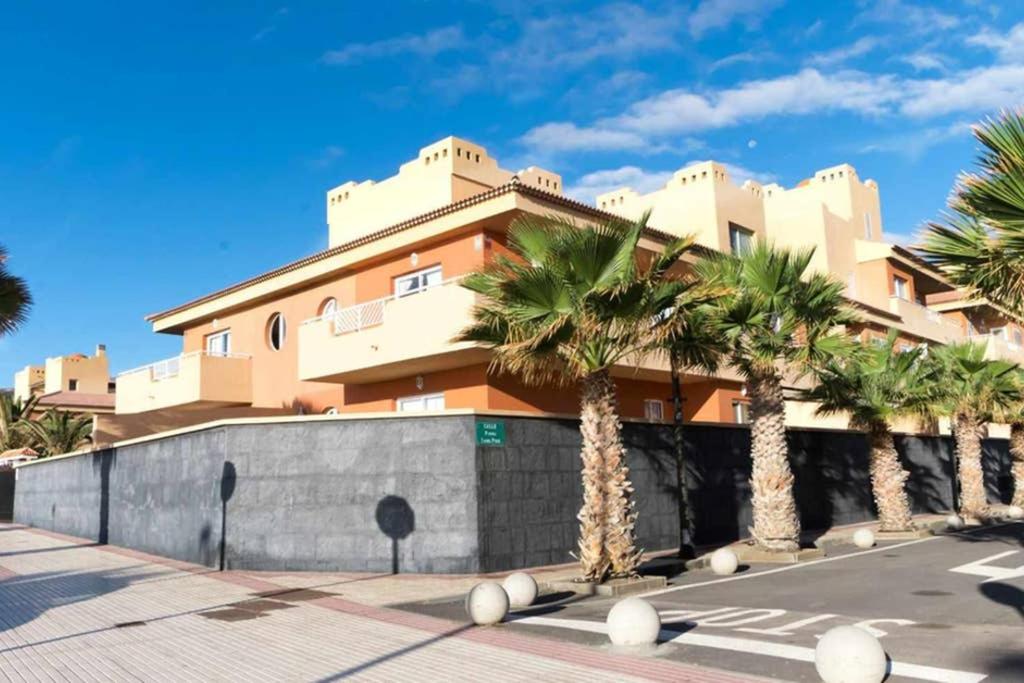 ein Gebäude mit Palmen davor in der Unterkunft Vista Mar in Puertito de Güímar