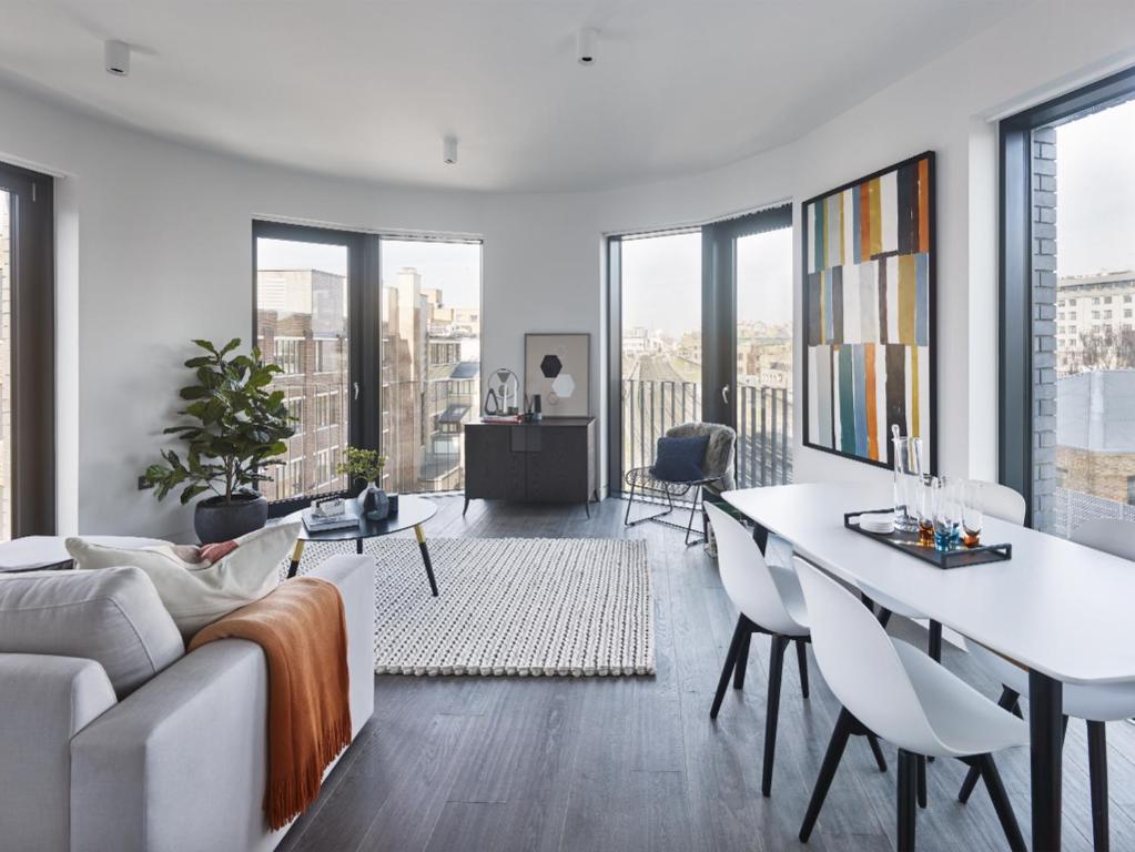 ein Wohnzimmer mit einem Sofa und einem Tisch in der Unterkunft The Eight Apartments Shoreditch in London