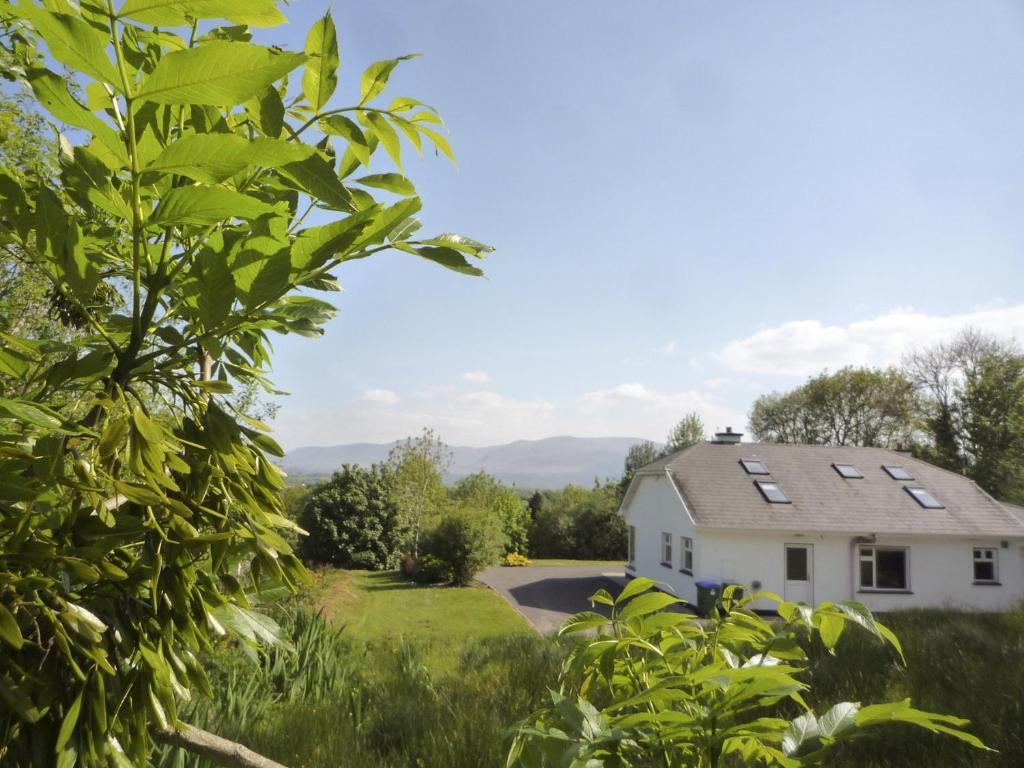 a white house with solar panels on its roof at Madams Hill House Killarney in Killarney