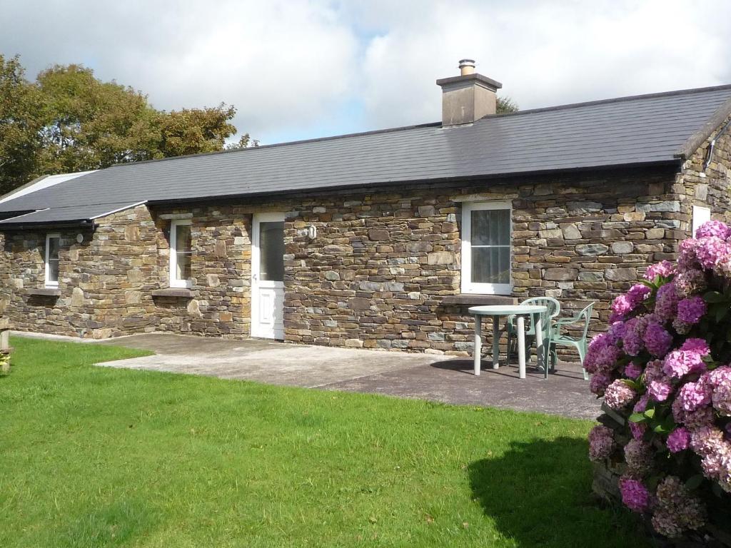 a stone house with a table in front of it at Lakeside Lodge Bantry in Bantry