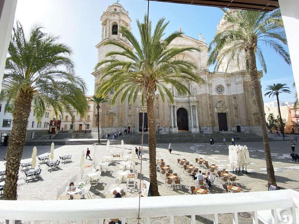un patio con palmeras frente a un edificio en Cathedral apartamento con balcon en Cádiz