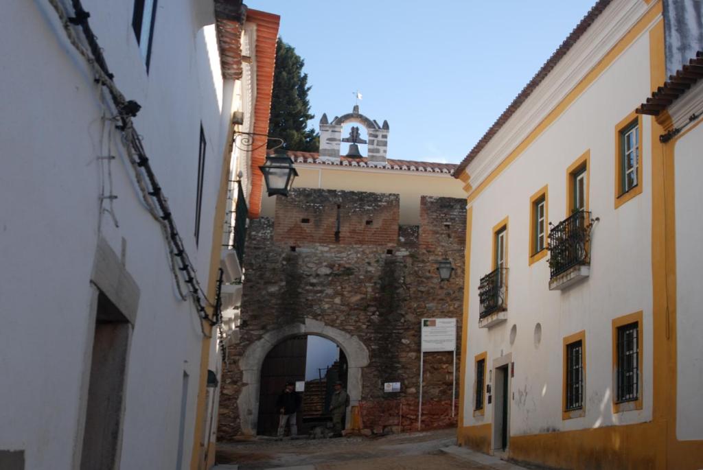 an alley with an archway and a clock tower at Casa de Viana do Alentejo in Viana do Alentejo