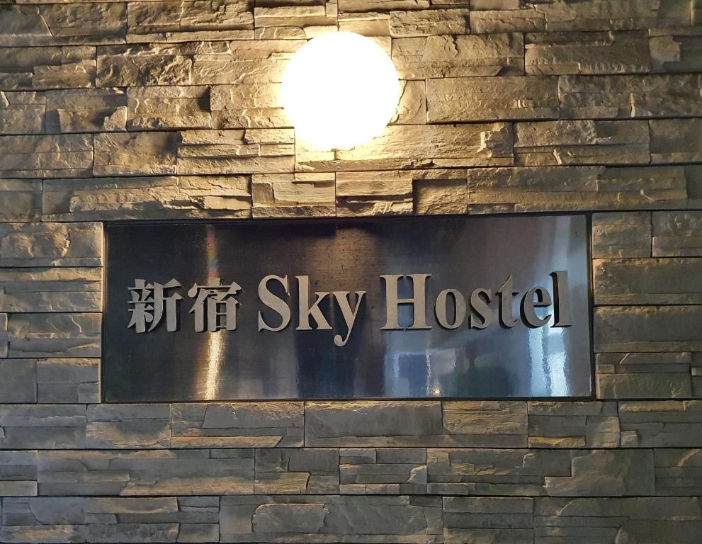 un cartello sul muro di un hotel sky di Shinjuku Sky hostel a Tokyo