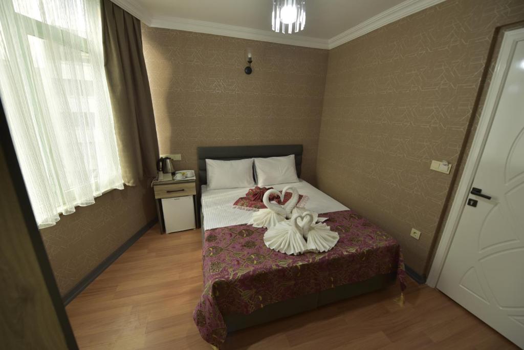 A bed or beds in a room at Omega Luxx Hotel