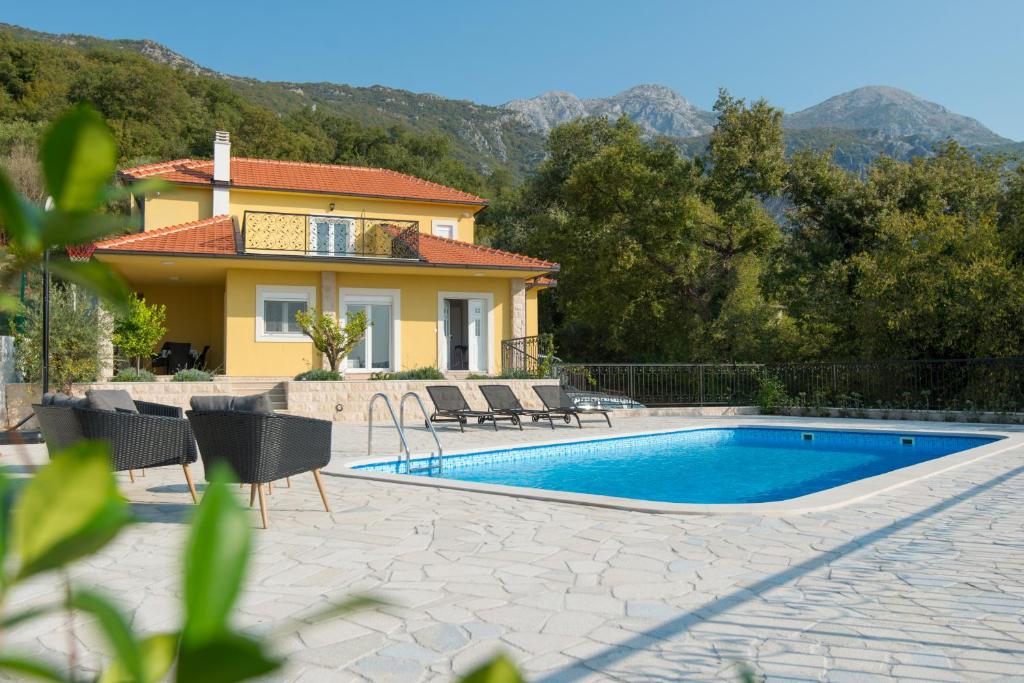 uma villa com piscina em frente a uma casa em Villa Belle Air em Herceg Novi