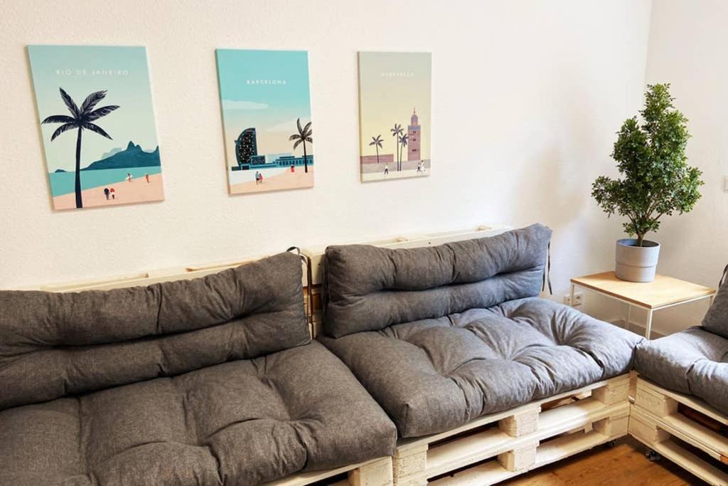 a couch in a living room with pictures on the wall at Luxus Apartment I , Netflix, Küche und Gym in Reken
