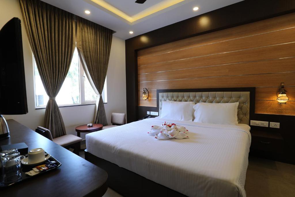 um quarto de hotel com uma cama grande e uma secretária em Mayuraa Residency em Chennai