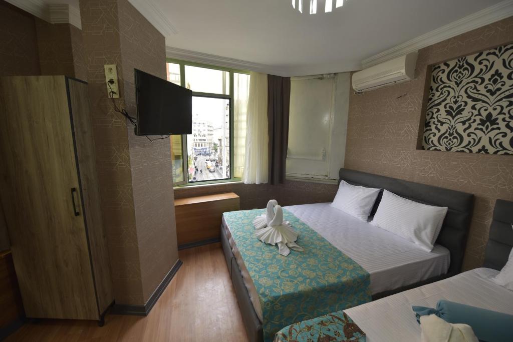 A bed or beds in a room at Omega Luxx Hotel