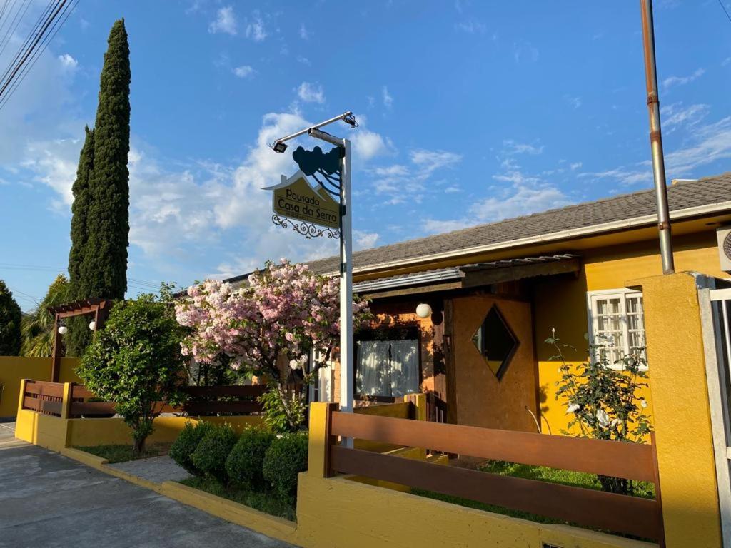 un letrero de la calle frente a un edificio amarillo en Pousada Casa da Serra, en Urubici