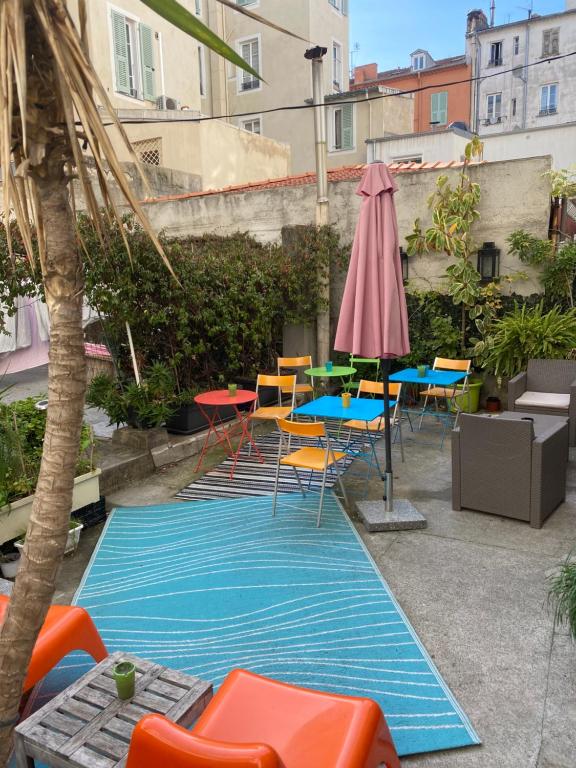 a swimming pool with chairs and a table and an umbrella at Le Pastoral in Nice