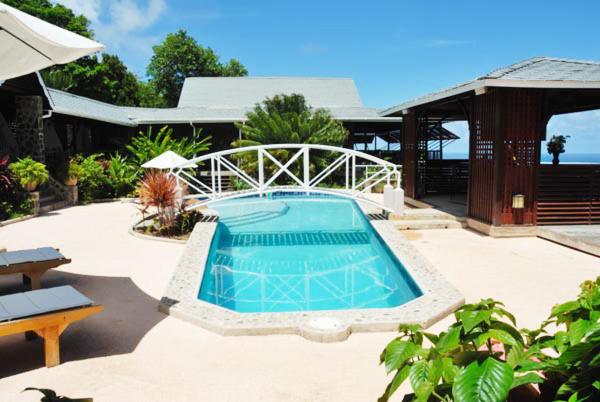 a swimming pool in the middle of a patio at Spring Hotel Bequia in Port Elizabeth