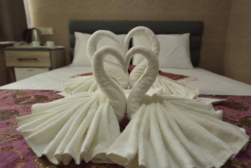 A bed or beds in a room at Omega Luxx Hotel