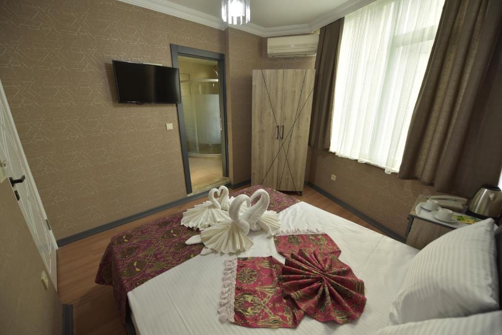 A bed or beds in a room at Omega Luxx Hotel