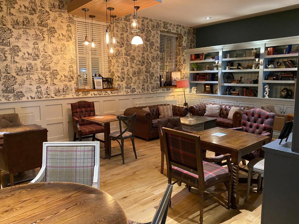 a restaurant with tables and chairs in a room at The Plough in Alnwick