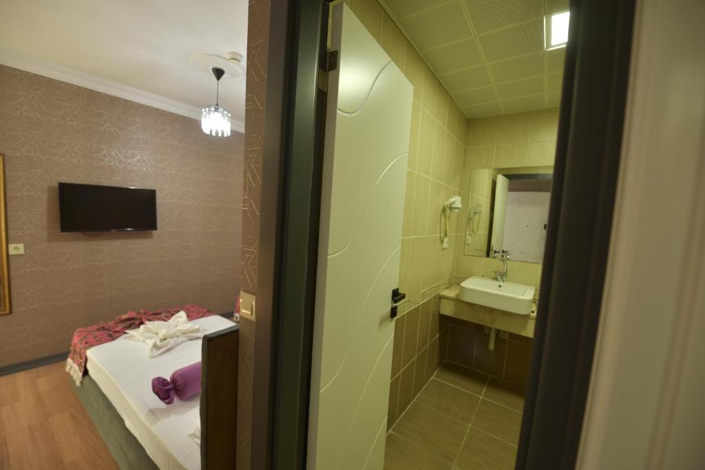 A bed or beds in a room at Omega Luxx Hotel