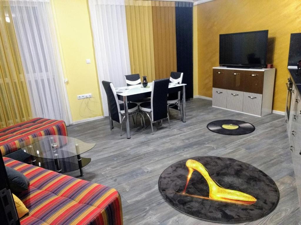 a living room with a table with a yellow shoe on the floor at Valentina GOLD apartment in Plovdiv