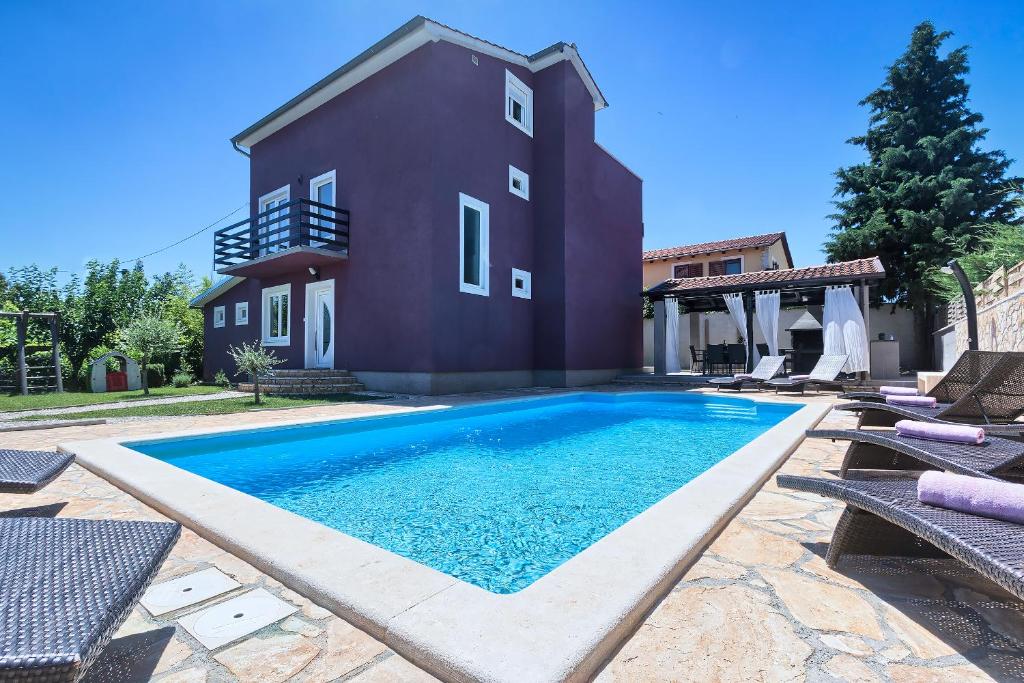 a swimming pool in front of a house at Villa Nina in Tar