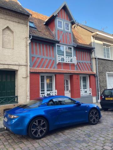 un coche azul estacionado frente a una casa roja en Le Rendez-vous du Pêcheur 4 à 6 pers, en Dieppe