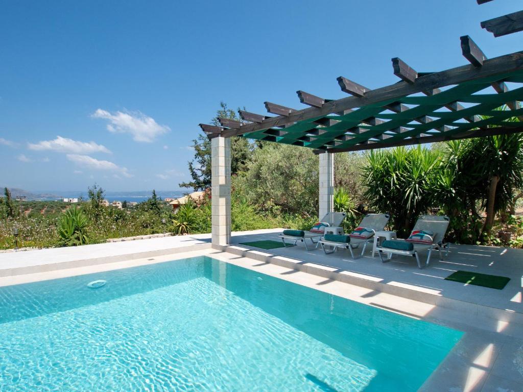 - une piscine avec des chaises et une pergola dans l'établissement Villa Nynemia Almyrida Crete, à Pláka