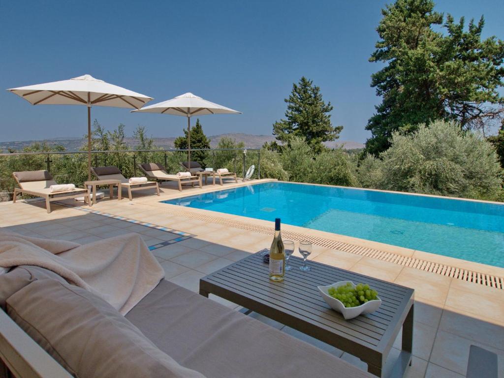 una villa con piscina e tavolo con una bottiglia di vino di Villa Olivia with Pool Vrises Crete ad Alíkambos