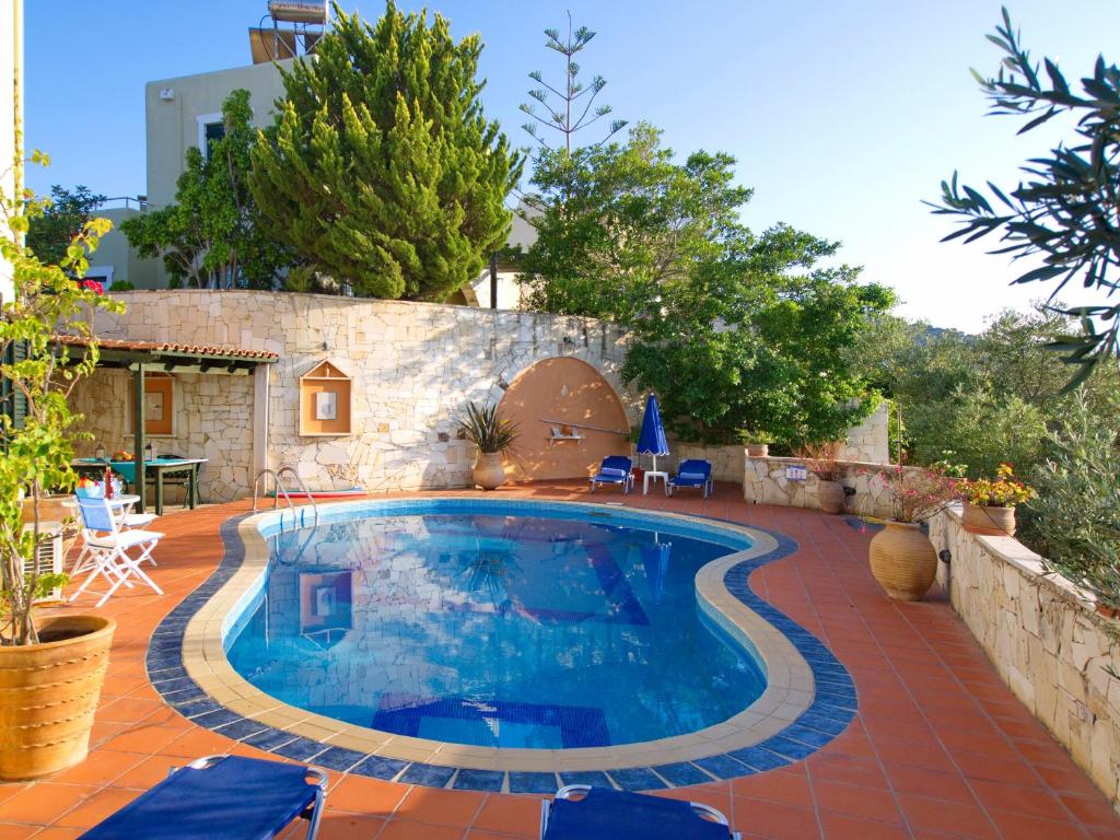 uma piscina num quintal com um pátio em Villa Panos in Stalos em Stalos
