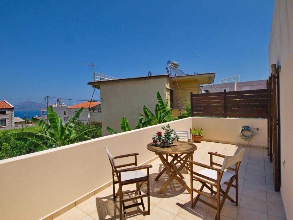 een patio met een tafel en stoelen op een balkon bij Villa Argiro Plaka Crete in Plaka