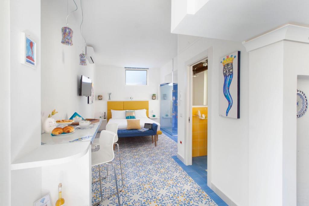 ein weißes Zimmer mit einem Bett und einem Tisch in der Unterkunft Vivaldo Suite - Fuoro in Sorrent