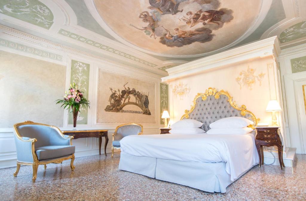 a bedroom with a bed and a ceiling with a painting at Ca' Bonfadini Historic Experience in Venice