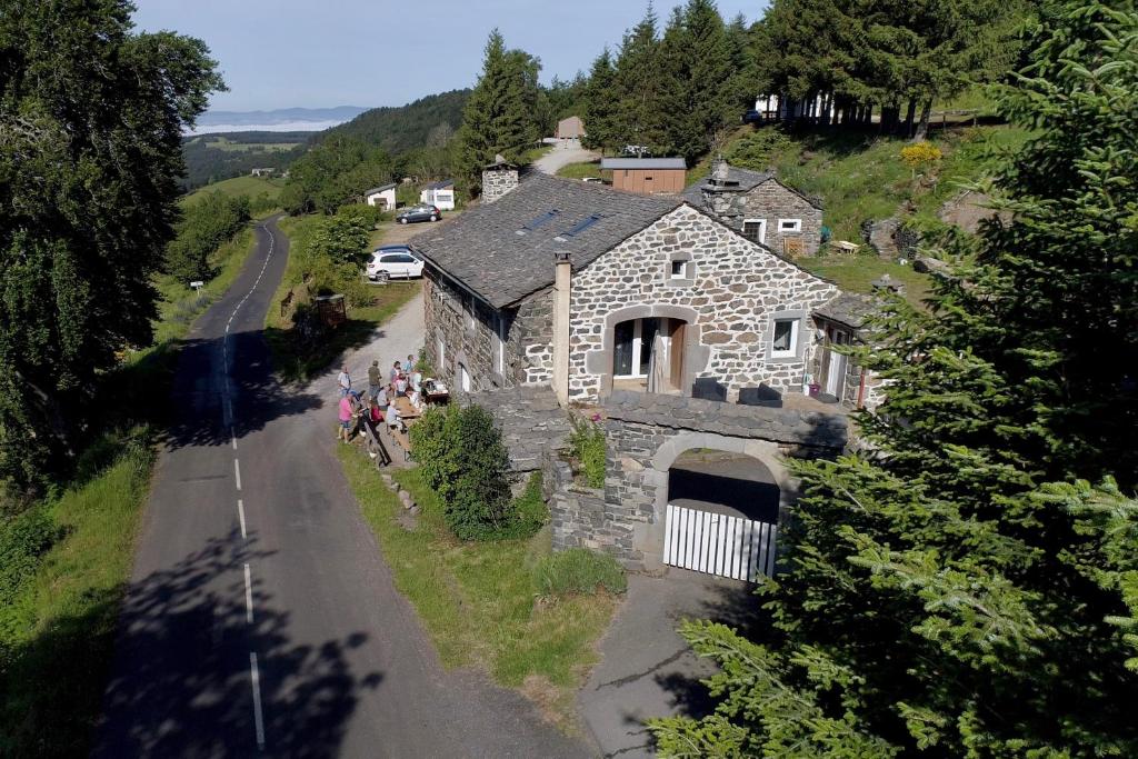 eine Gruppe von Menschen, die vor einem Steinhaus stehen in der Unterkunft Espace Nature Sabatoux in Montusclat