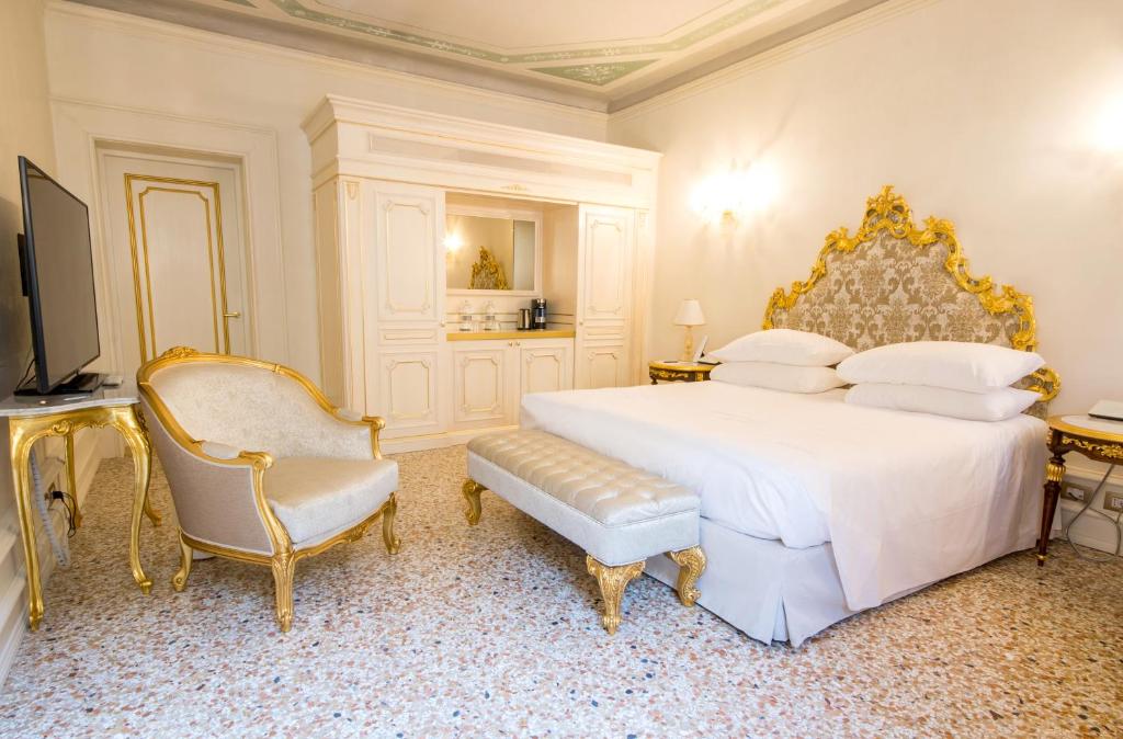 a bedroom with a large white bed and a chair at Ca' Bonfadini Historic Experience in Venice