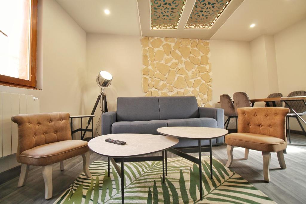 una sala de espera con sofá, mesas y sillas en LOCBNB - TOURISM and BUSINESS LOCATIONS - ALSACE - BARR CENTRE - ROUTE DES VINS, en Barr